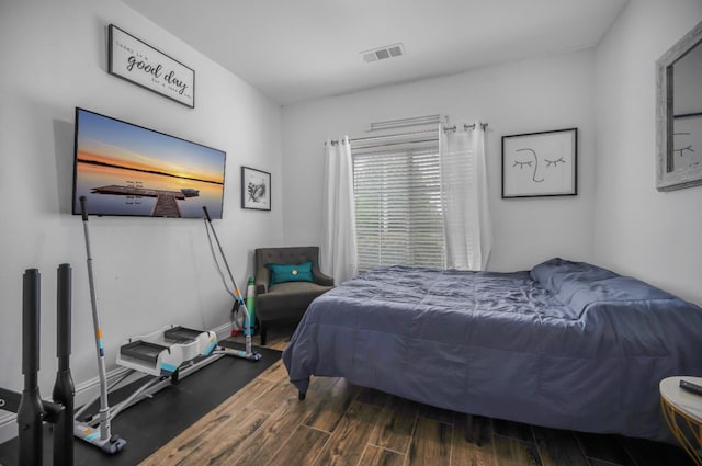 bedroom featuring wood finished floors, visible vents, and baseboards
