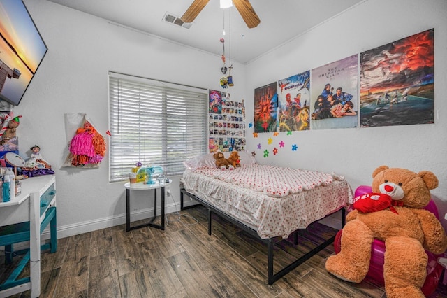 bedroom with wood finished floors, visible vents, a ceiling fan, and baseboards