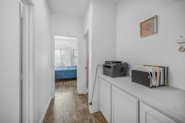 hall featuring baseboards and wood finished floors
