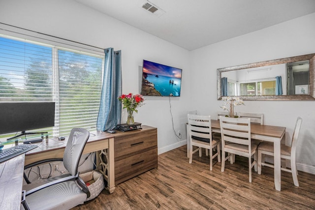 office space with wood finished floors, visible vents, and baseboards