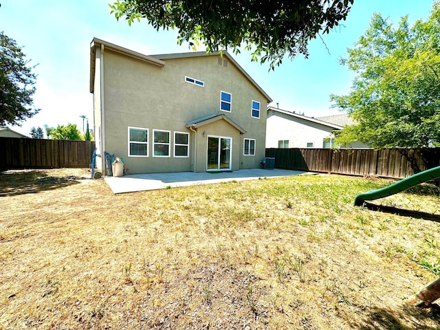 5148 W Pine Ave, Fresno, CA 93722 - back of house with cooling unit, a fenced backyard, a patio, and stucco siding