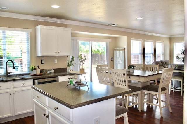 5148 W Pine Ave, Fresno, CA 93722 - kitchen with dark countertops, a sink, dark wood-style flooring, visible vents, and a kitchen island
