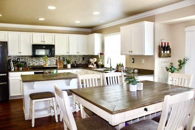 5148 W Pine Ave, Fresno, CA 93722 - kitchen with white cabinets, dark countertops, a sink, crown molding, and black appliances