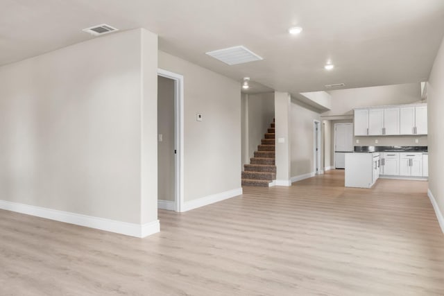 3659 Mono St, Fresno, CA 93702 - unfurnished living room with light wood finished floors, stairway, and recessed lighting