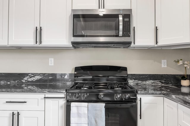 3659 Mono St, Fresno, CA 93702 - kitchen with black range with gas stovetop, stainless steel microwave, white cabinets, and dark stone counters