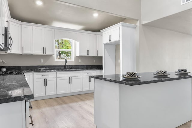 3659 Mono St, Fresno, CA 93702 - kitchen featuring stainless steel microwave, white cabinetry, dark stone countertops, and recessed lighting