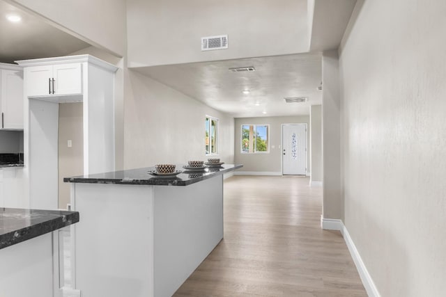 3659 Mono St, Fresno, CA 93702 - kitchen with light wood-type flooring, white cabinetry, dark stone counters, and open floor plan