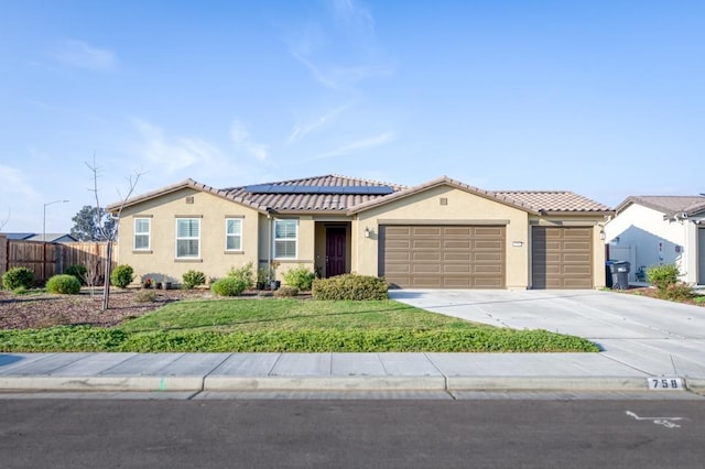 view of front of house featuring a garage, stucco siding, fence, and solar panels