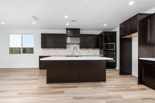 kitchen with stainless steel microwave, visible vents, oven, and a sink