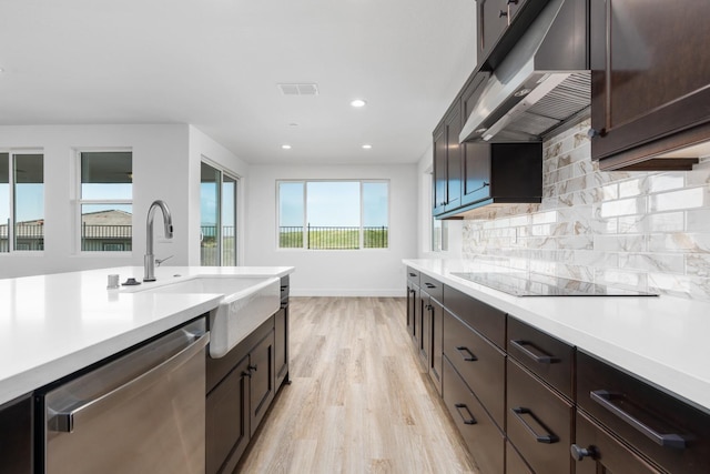 kitchen with light countertops, under cabinet range hood, dishwasher, and black electric stovetop