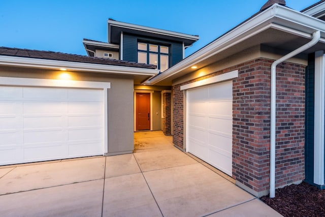 view of front of house featuring brick siding, driveway, and a garage