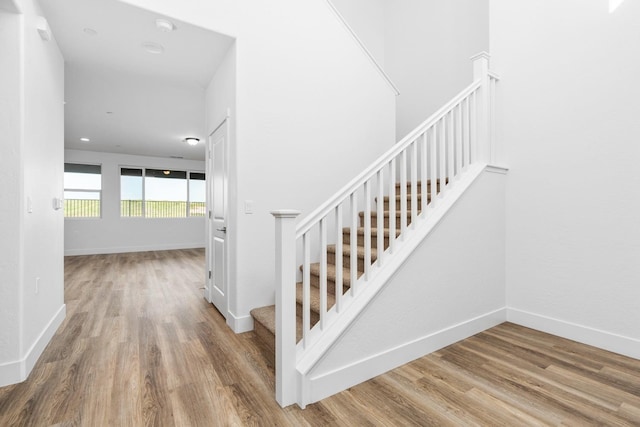 stairway featuring wood finished floors and baseboards