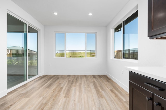 spare room featuring recessed lighting, light wood finished floors, and baseboards