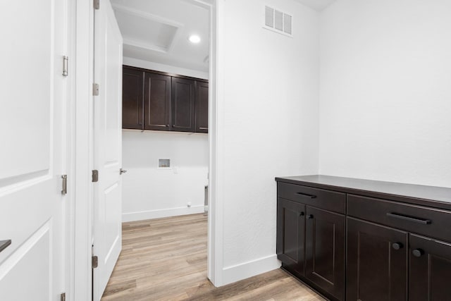 hallway featuring light wood-style flooring, visible vents, and baseboards