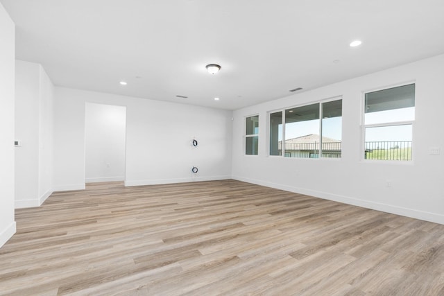 empty room featuring baseboards, light wood finished floors, and recessed lighting