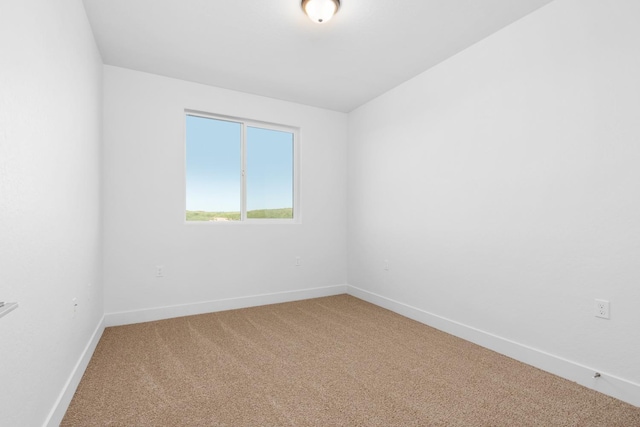 empty room with baseboards and carpet