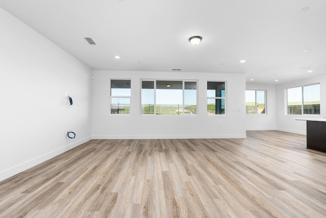 unfurnished living room with baseboards, light wood-style floors, visible vents, and recessed lighting