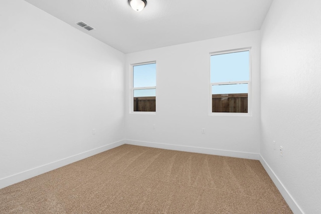 empty room with light carpet, baseboards, and visible vents