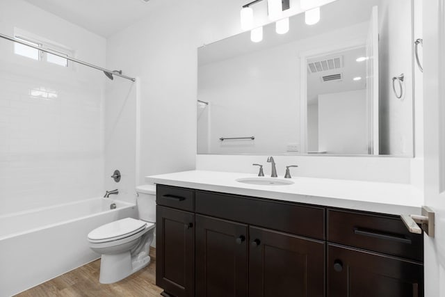 bathroom featuring wood finished floors, vanity, shower / tub combination, toilet, and visible vents