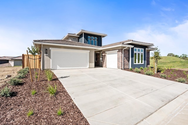 8184 Creek Vw, Friant, CA 93626 - prairie-style home with a garage, driveway, stucco siding, and brick siding
