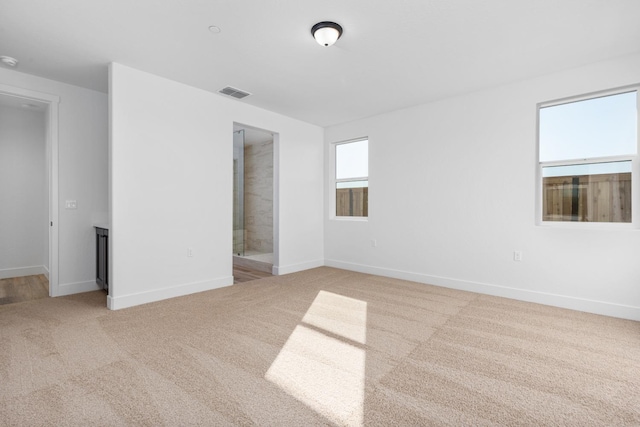 empty room featuring baseboards, visible vents, and carpet