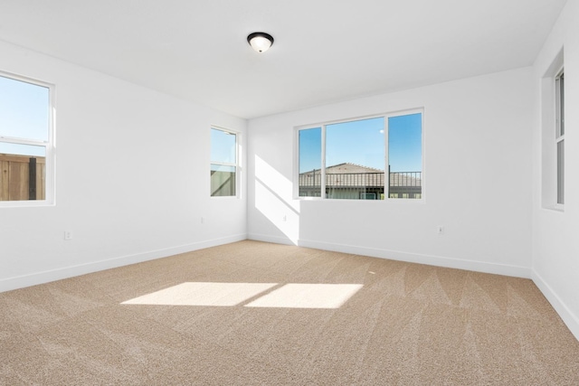 unfurnished room with light carpet and baseboards