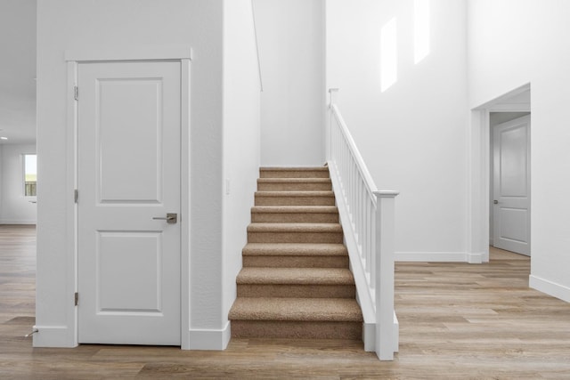 staircase with wood finished floors and baseboards