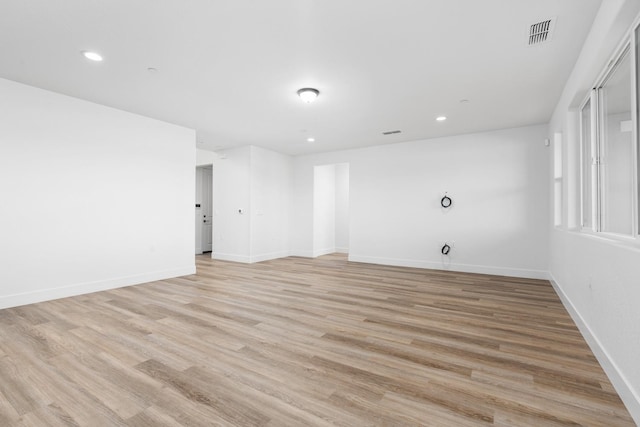 unfurnished room with baseboards, light wood-style floors, visible vents, and recessed lighting