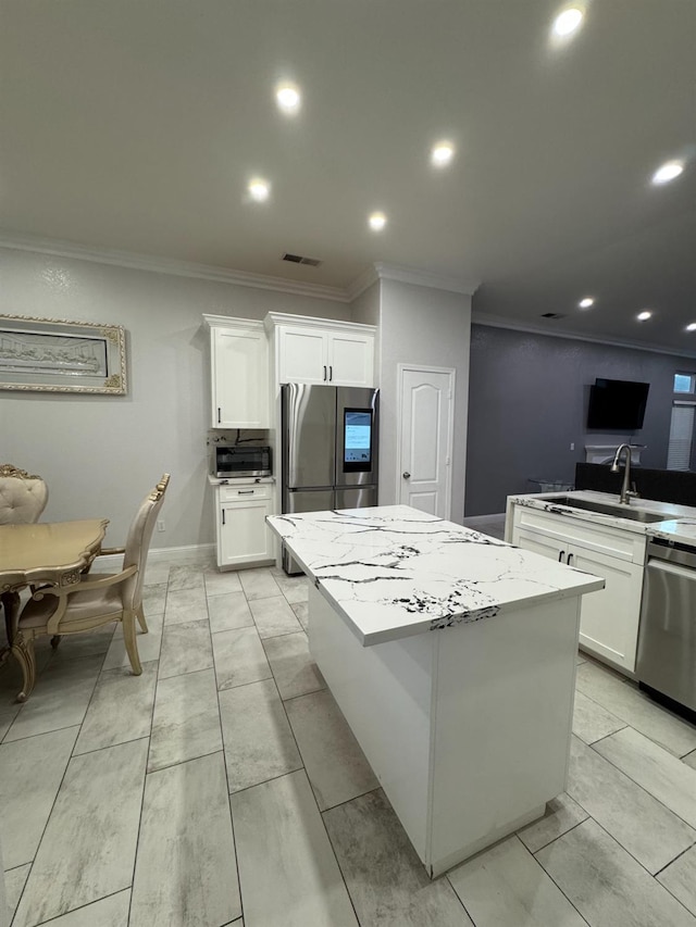 5357 E Burns, Fresno, CA 93725 - kitchen with ornamental molding, stainless steel appliances, a kitchen island, white cabinetry, and recessed lighting