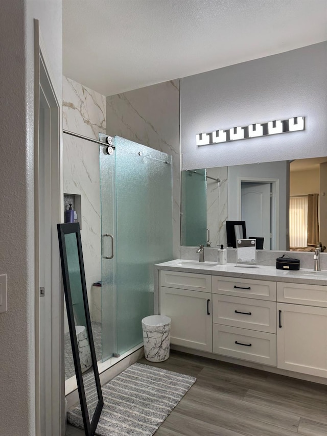 5357 E Burns, Fresno, CA 93725 - bathroom with wood finished floors, a sink, double vanity, and a stall shower