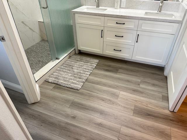 5357 E Burns, Fresno, CA 93725 - full bath with a marble finish shower, wood finished floors, and double vanity