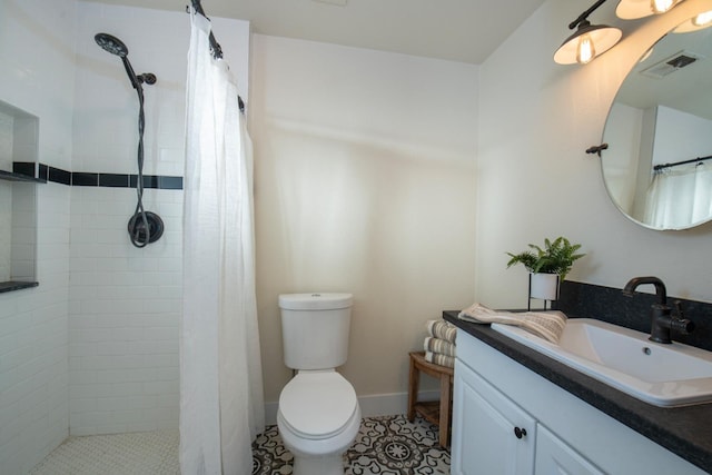full bathroom with toilet, vanity, baseboards, visible vents, and tiled shower