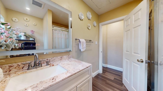 full bathroom with visible vents, baseboards, wood finished floors, curtained shower, and vanity