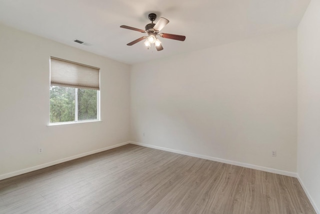 unfurnished room featuring baseboards, light wood-style flooring, visible vents, and a ceiling fan