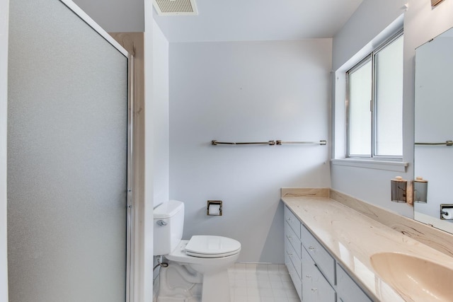 bathroom featuring toilet, vanity, a shower with shower door, baseboards, and visible vents