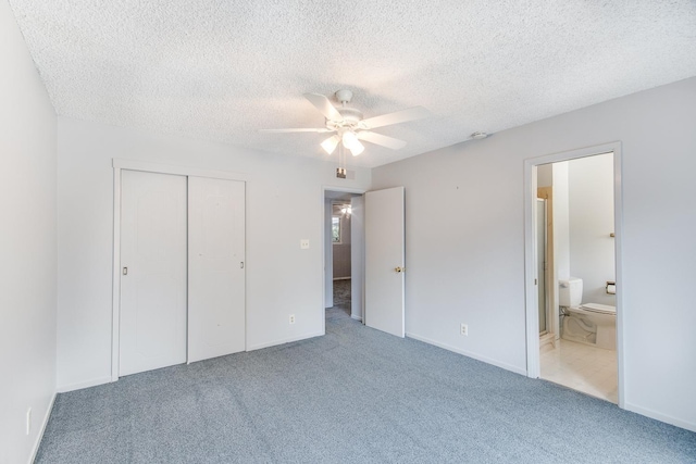 unfurnished bedroom featuring connected bathroom, carpet floors, a closet, baseboards, and a textured ceiling