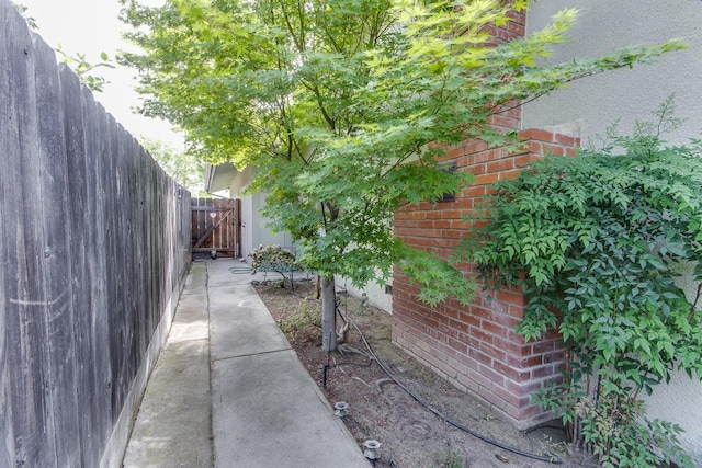 view of property exterior with brick siding and fence