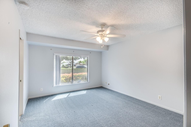 spare room featuring carpet floors, a textured ceiling, a ceiling fan, and baseboards