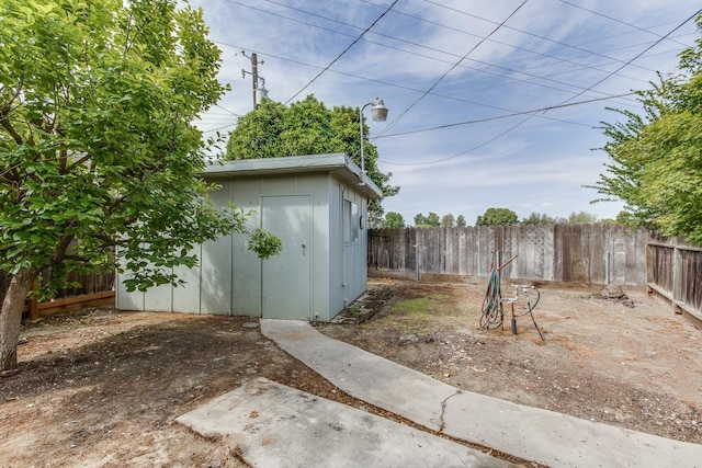 exterior space featuring a fenced backyard, an outbuilding, and a shed