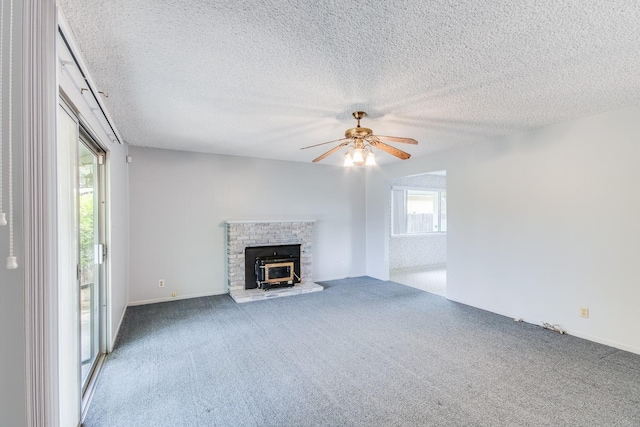 unfurnished living room featuring a wealth of natural light, a ceiling fan, carpet flooring, and a textured ceiling
