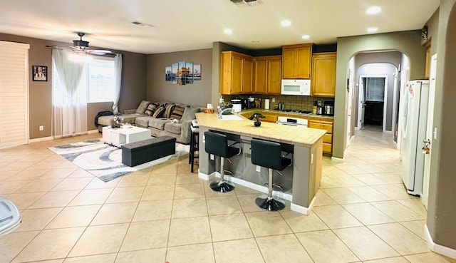 2148 S Villa Ave, Fresno, CA 93727 - kitchen with a peninsula, open floor plan, white appliances, a breakfast bar, and tile countertops