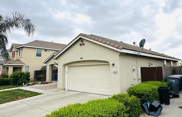 2148 S Villa Ave, Fresno, CA 93727 - view of front of property featuring fence, a tiled roof, stucco siding, an attached garage, and driveway
