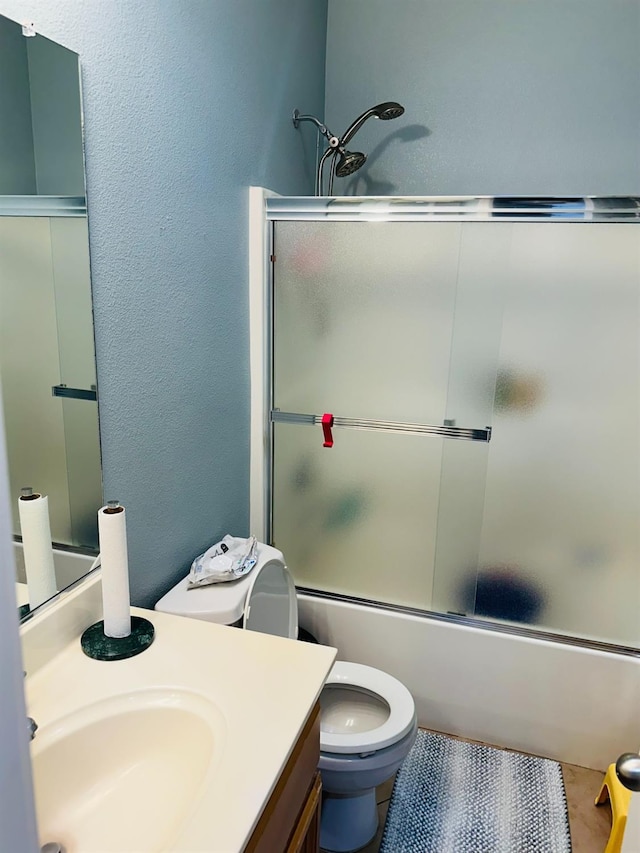 2148 S Villa Ave, Fresno, CA 93727 - full bath featuring a textured wall, vanity, shower / bath combination with glass door, and toilet