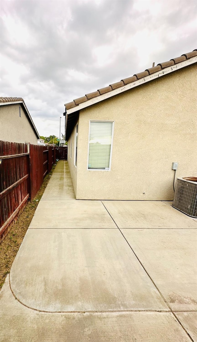 2148 S Villa Ave, Fresno, CA 93727 - view of side of home featuring central air condition unit, a patio area, a fenced backyard, and stucco siding