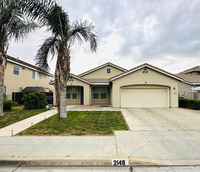 2148 S Villa Ave, Fresno, CA 93727 - ranch-style home with a tile roof, concrete driveway, an attached garage, a front yard, and stucco siding