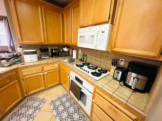 2148 S Villa Ave, Fresno, CA 93727 - kitchen featuring backsplash, tile counters, white appliances, and light tile patterned floors