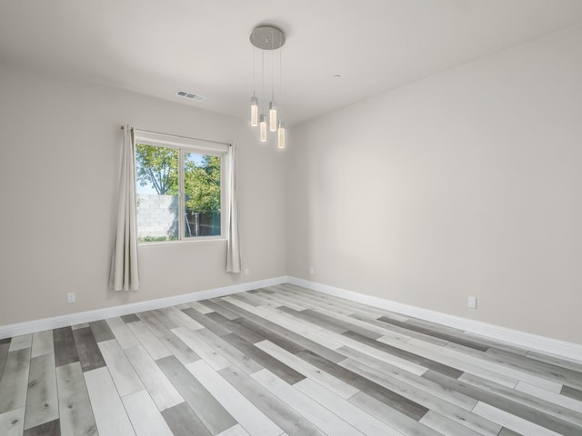 1026 E Carnoustie Ave, Fresno, CA 93730 - unfurnished room with light wood-style flooring, a chandelier, and visible vents