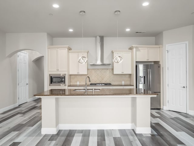 1026 E Carnoustie Ave, Fresno, CA 93730 - kitchen featuring wall chimney exhaust hood, an island with sink, dark stone countertops, and stainless steel appliances