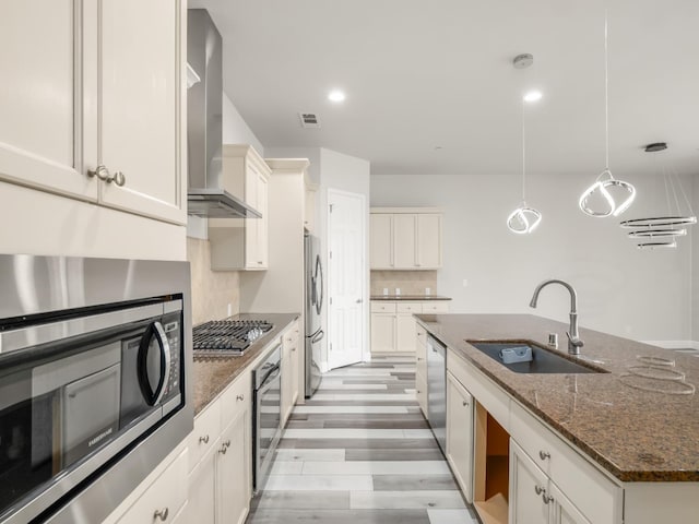 1026 E Carnoustie Ave, Fresno, CA 93730 - kitchen with wall chimney range hood, visible vents, appliances with stainless steel finishes, a sink, and an island with sink