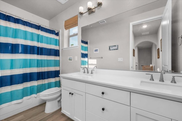 2653 Vermont Ave, Clovis, CA 93619 - bathroom featuring toilet, double vanity, wood finished floors, and a shower with curtain